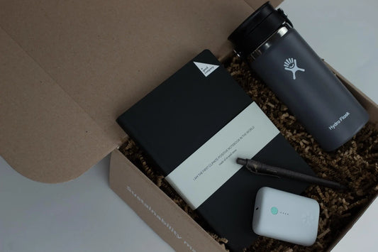 Eco-friendly gift biox that includes a notebook, pen, coffee packages, and tin pint.